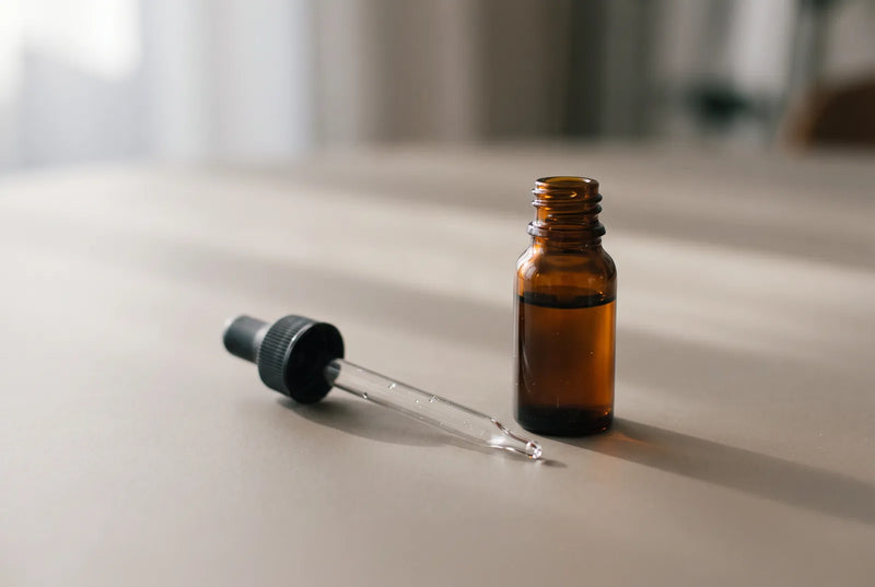 Pastilles à laisser fondre dans une main ouverte, sur fond neutre, à côté d'une brosse à dents